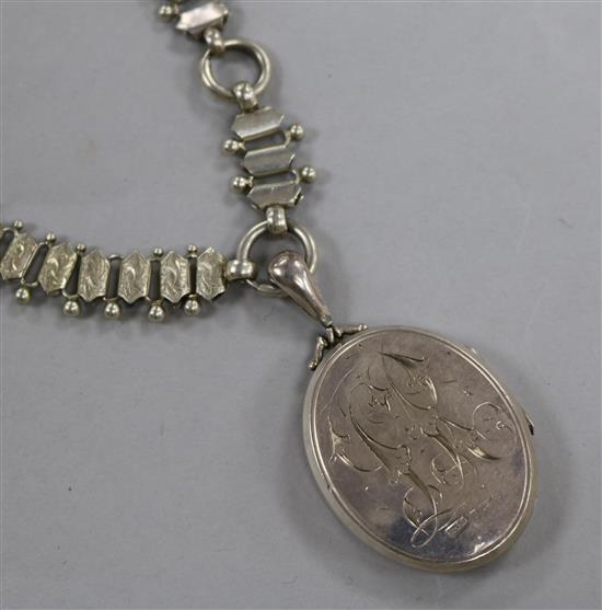 A Victorian silver oval locket with overlaid yellow metal floral decoration, on an ornate white metal chain, locket 43mm.